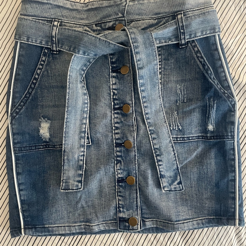 Denim skirt with belt, buttons and white piping down both sides. So cute!